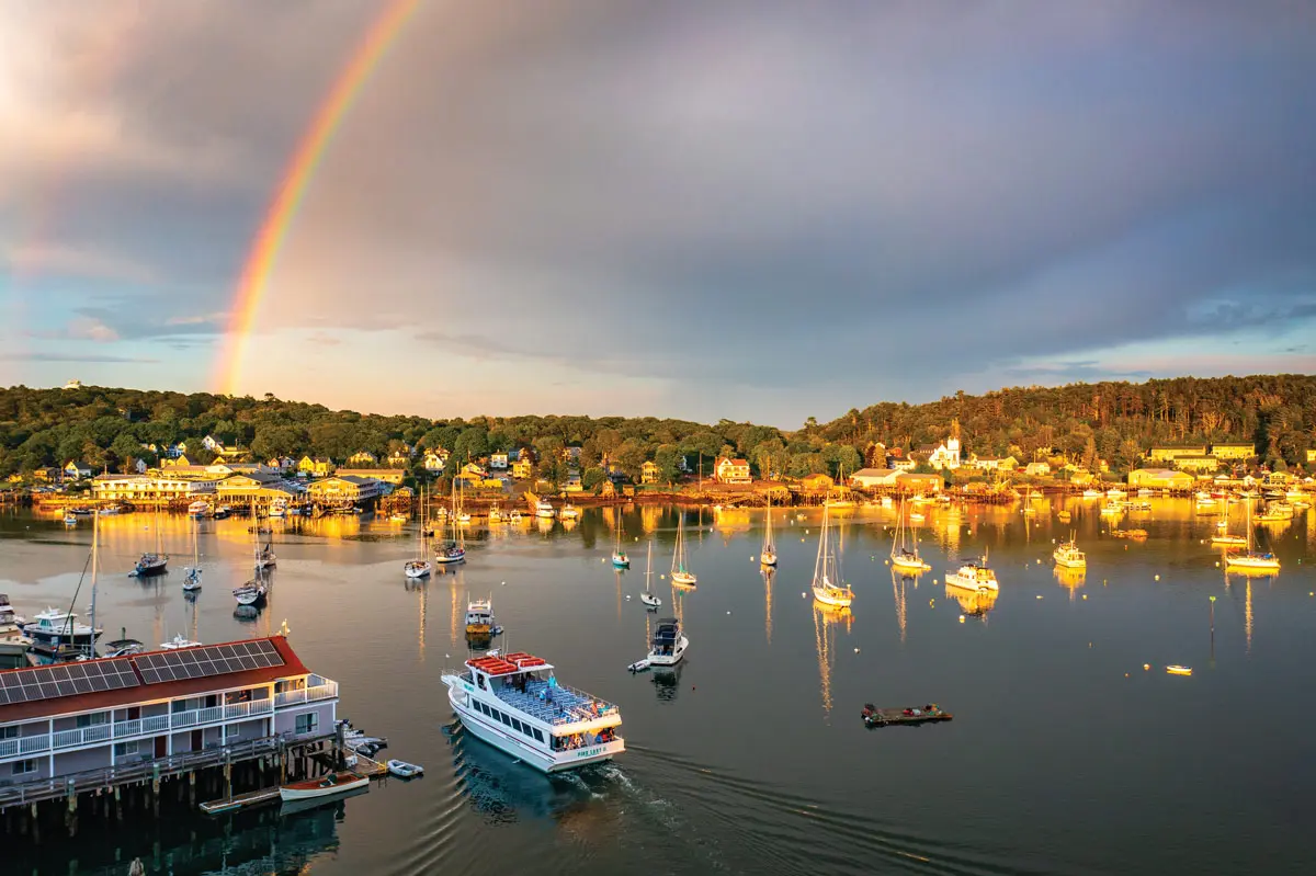 Boothbay Harbor viewed across the water beneath a rainbow